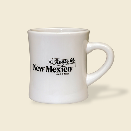 White mug with 'Route 66 New Mexico Magazine' text on a beige background